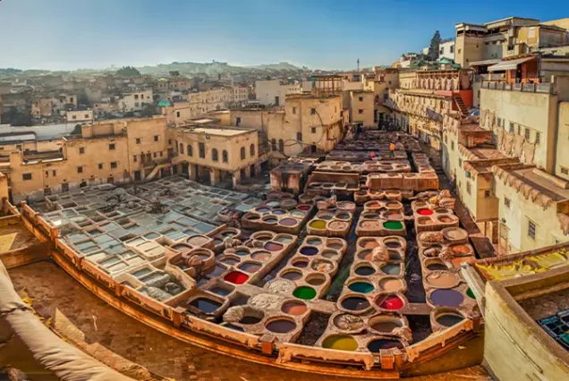 A view of the Chouara Tannery in Fes, showcasing the vibrant dyeing vats and traditional leatherwork process.